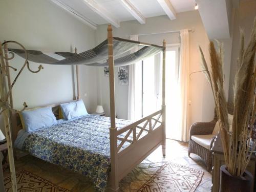 a bedroom with a canopy bed and a window at Volidiera Guesthouse in Lixouri