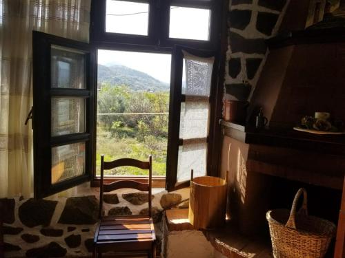 a room with a window with a chair and a fireplace at bed & breakfast Local Living Edi in Berat