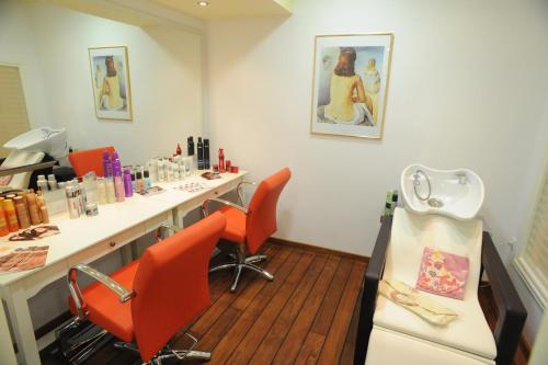 a room with a hair salon with orange chairs at Lianos Village in Agios Prokopios