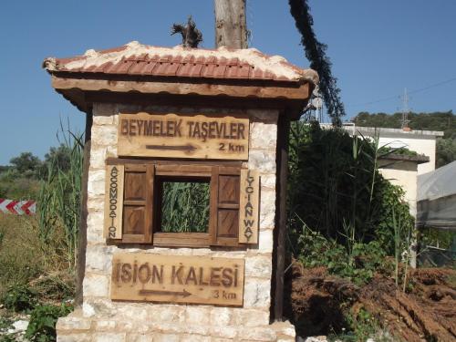 a cat sitting on top of a sign on a building at Beymelek Tas Evler in Demre