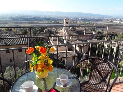 a table with a vase of flowers on a balcony at Suite Luna Bianca in Assisi