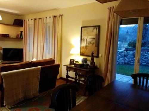 a living room with a couch and a table and a window at La Majada de Alameda in Alameda del Valle