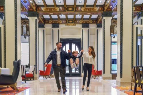 a man and a woman walking through a lobby with a child at Hotel Spero, Vignette Collection by IHG in San Francisco