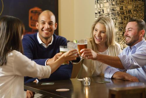 a group of people sitting around a table drinking beer at Hotel Spero, Vignette Collection by IHG in San Francisco