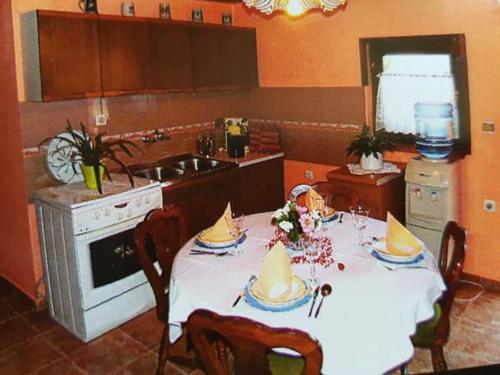 una cocina con una mesa con sombreros. en Apartman Kalinka, en Gajić