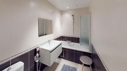 een badkamer met een wastafel, een toilet en een douche bij Deluxe Apartment with Shared Pool in Oostende