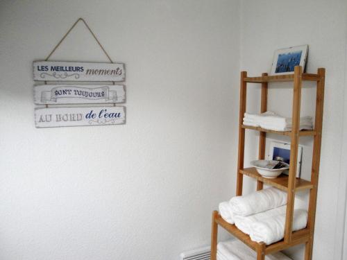a bathroom with a towel shelf and a sign on a wall at Résidence Arguin 2 in Arcachon