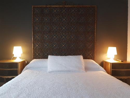 塔維亞諾勒斯的住宿－El Nou Roquet，卧室配有带两盏灯的白色床