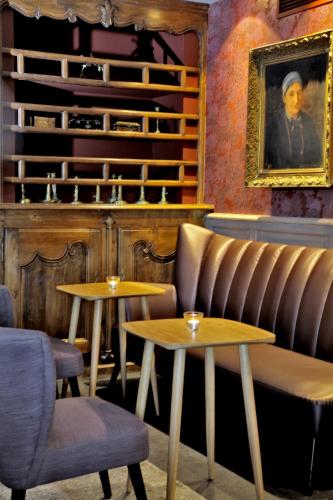 a restaurant with two tables and a painting on the wall at Les Glycines - Hôtel & Spa - Teritoria in Les Eyzies-de-Tayac