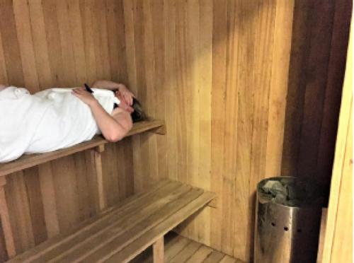 a person laying in bed in a wooden room at Anoud Manor in Hout Bay