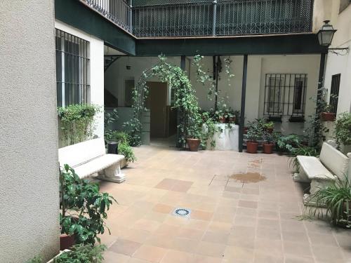 an outdoor patio with white benches and plants at Hostal San Blas in Madrid