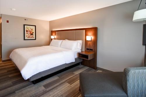 une chambre d'hôtel avec un lit et un canapé dans l'établissement Holiday Inn Express & Suites Schererville by IHG, à Schererville