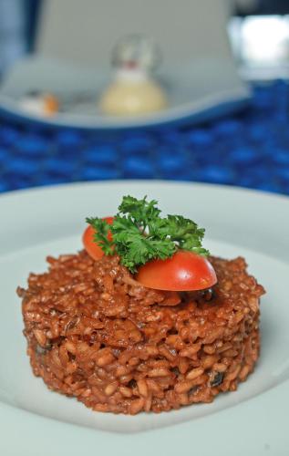 a plate of food with a tomato on top of beans at Kitewind Apartamentos Cabarete in Cabarete