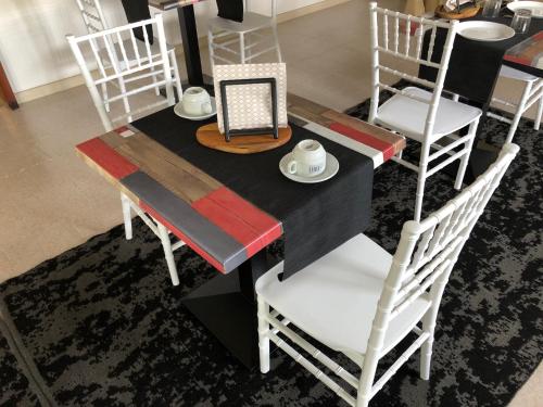 une table de salle à manger avec des chaises blanches et une table noire dans l'établissement L'Incanto di Paestum, à Capaccio-Paestum
