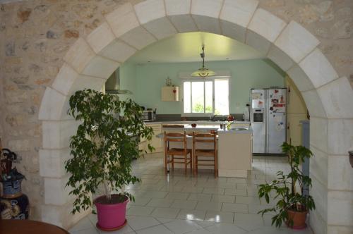 Eyzerac的住宿－Domaine de Chantegros，厨房内的拱门,配有桌子和冰箱