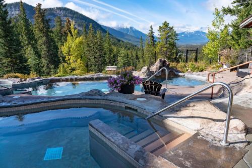 a swimming pool with a mountain in the background at The Hidden Ridge Resort in Banff