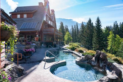 a house with a swimming pool in front of a house at The Hidden Ridge Resort in Banff