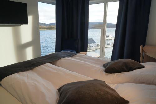 A bed or beds in a room at Senja Fjordhotell and Apartments