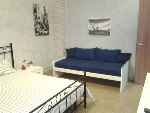 un soggiorno con divano blu e letto di Long Bridge House a Roma