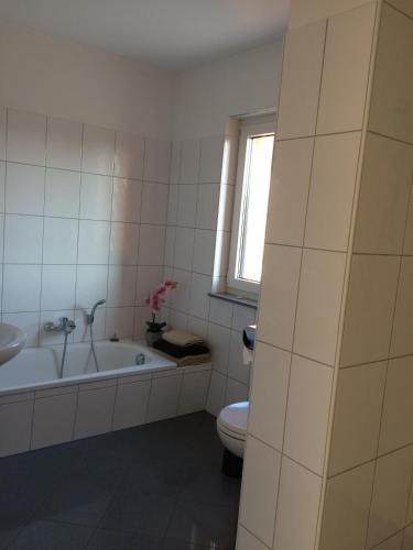 La salle de bains est pourvue d'une baignoire, de toilettes et d'une fenêtre. dans l'établissement 58 Puschkinstraße, à Wittemberg