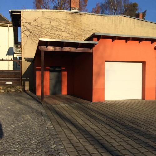 een garage met twee witte garagedeuren op een gebouw bij 58 Puschkinstraße in Lutherstadt Wittenberg