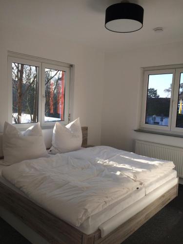 - un lit blanc dans une chambre avec 2 fenêtres dans l'établissement 58 Puschkinstraße, à Wittemberg