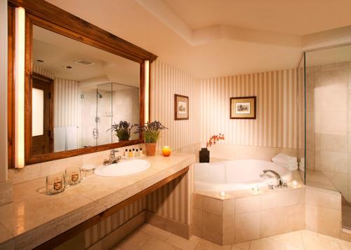 a bathroom with a tub and a sink and a mirror at Austria Haus Hotel in Vail