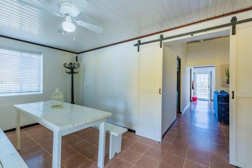 a dining room with a white table and a hallway at Old Aloe House in Savaneta