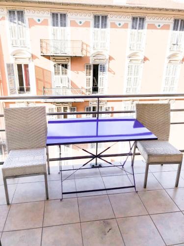 une table bleue et deux chaises sur un balcon dans l'établissement Portobello residence, à Nice