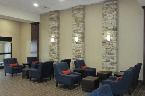 uma sala de espera com cadeiras azuis e almofadas vermelhas em MainStay Suites Coeur d'Alene em Coeur d'Alene