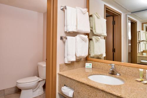 un bagno con lavandino, water e specchio di Stage Coach Inn a West Yellowstone