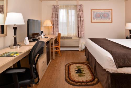 una camera d'albergo con letto e scrivania con computer di Stage Coach Inn a West Yellowstone