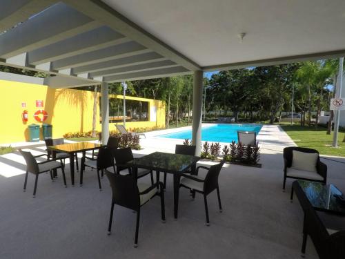 a patio with tables and chairs and a pool at PlayaTurquesa Moderna Casa C/R Auto a 9 min 5ta ave in Playa del Carmen