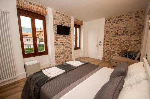 1 dormitorio con 1 cama en una habitación con una pared de piedra en Case Vacanza Skipper, en Pettenasco