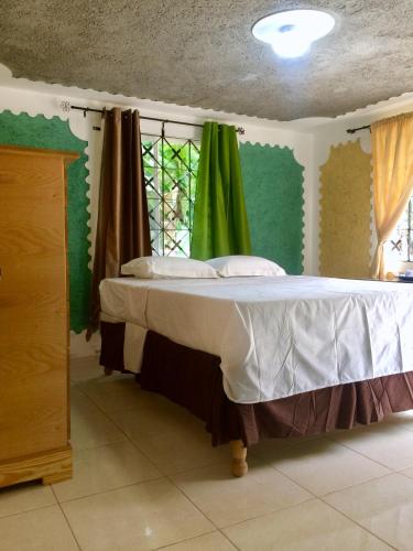 a bedroom with a large bed with a window at Becaville in Port Antonio