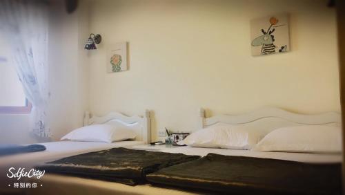 a bedroom with two beds and two pictures on the wall at Just Coffee Hostel 5 in Beigan