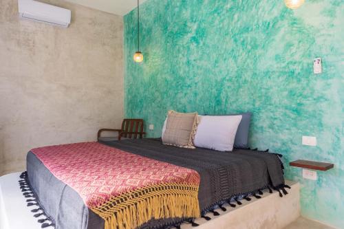 a bedroom with a bed with a green wall at Turquoise Tulum Hotel in Tulum