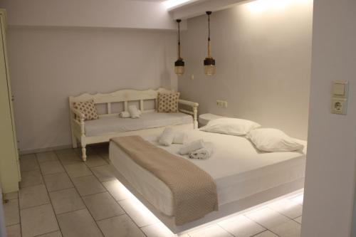 two beds in a white room with lights at Vasilikos Studios in Naxos Chora