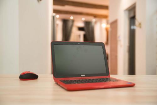 a red laptop computer sitting on a table with a mouse at full 4 floors house at the center in Antwerp