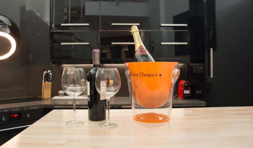 a bottle of wine in a bucket next to two wine glasses at full 4 floors house at the center in Antwerp