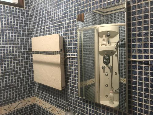 een blauw betegelde badkamer met een urinoir en een spiegel bij Casa da 25 in Espinho