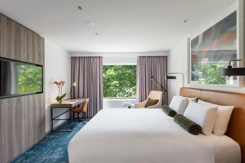a hotel room with a large bed and a desk at Novotel Sydney Darling Square in Sydney