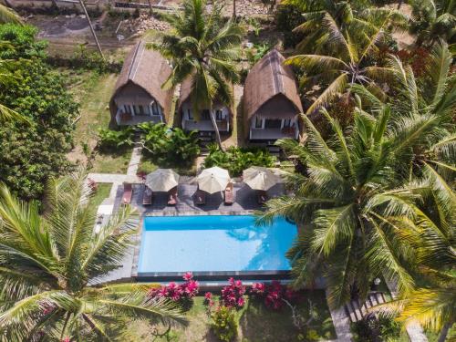 an aerial view of a resort with a swimming pool and palm trees at Bintang Bungalow in Nusa Penida