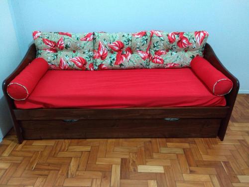 a red couch sitting on top of a wooden floor at Apto Mariza Copacabana in Rio de Janeiro