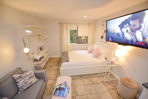 a living room with a couch and a tv on the wall at Newly Renovated Whistler Studio in Whistler
