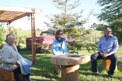 a group of three people sitting around a table at Cabañas 4 Volcanes Frutillar in Frutillar