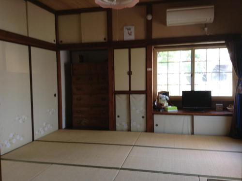 an empty room with a desk and two windows at Wataya Inn in Fujisawa