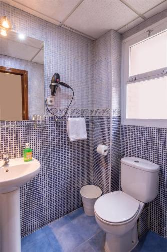 a bathroom with a toilet and a sink at Hotel Mexico in Madrid
