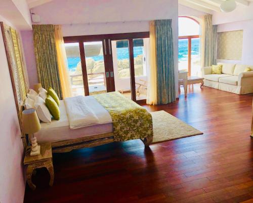 a bedroom with a bed and a living room at Thaproban Pavilion Resort and Spa in Unawatuna