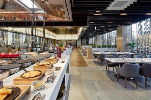 a dining room with tables and chairs and tablesktop at Somerset Jeju Shinhwa World in Seogwipo